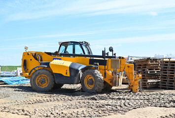 Yellow wheel loader machine transportation wooden pallet  cargo at the construction site