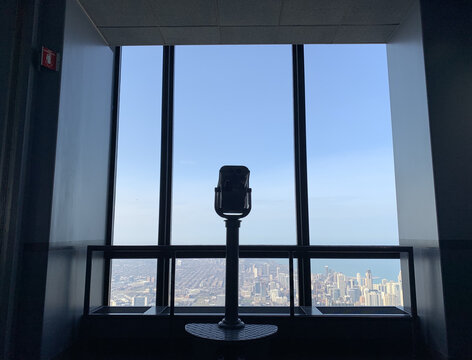 Closeup of the binocular telescope in front of windows at the observatory hall in Skydeck Chicago