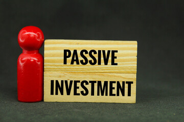 peg doll and wooden board with the word passive investment