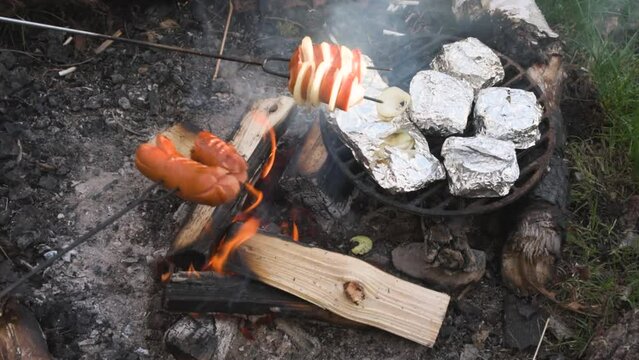 Campfire roasting cheese in alu foil bbq fire, hermelin type