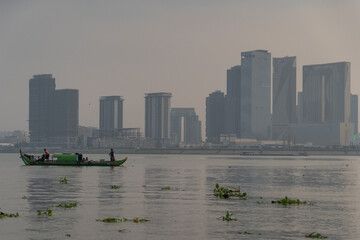 Silhouette of a fisherman on Tonle Sap Mekong junction in front of Sokha Phnom Penh at dusty sunset