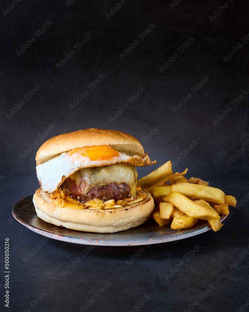 Sticker Vertical shot of The brunch burger on a plate with French fries.