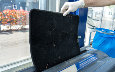 Man using automatic car mat cleaning machine at car service station