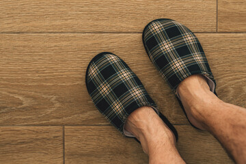 Male feet wearing plaid slippers in bathroom