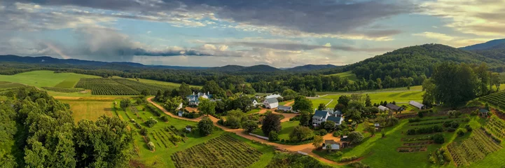 Foto op Canvas Aerial panoramic view of rural ranch with planted field near to a dense forest in bright sunlight © Michael Patch/Wirestock Creators