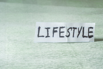 Fototapeta na wymiar Lifestyle,word written on a paper that is in a light green place.