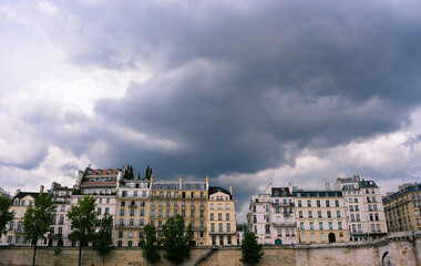 Beautiful low angle shot of the Quay of Orleans building in Paris, France against a gray cloudy sky