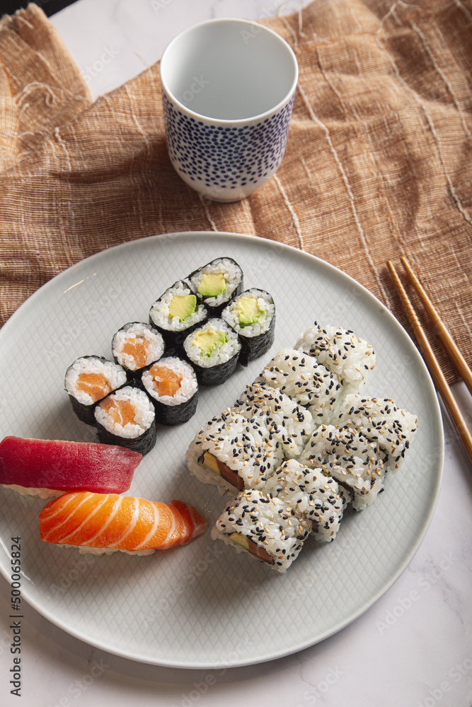 Poster japanese sushi nigiri and rolls mix served on a white plate