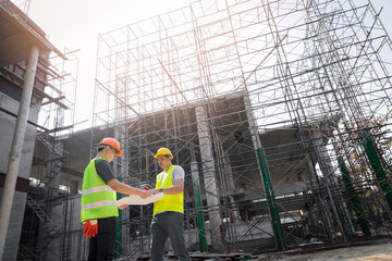 Confident team of architect working together in building construction site. They discussing about...