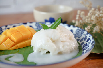 Sticky Rice with Ripe Mango in Coconut Milk Authentic Thai desserts on a wooden table