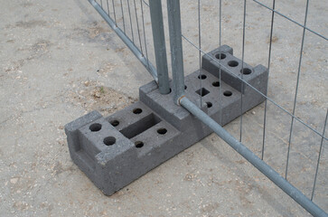 Concrete base with many holes for temporary portable fences for construction sites close