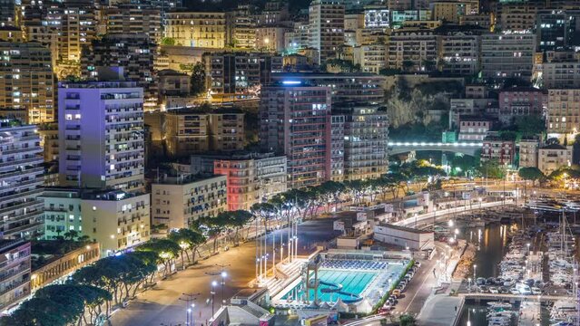 Seaside swimming pool in Monaco night timelapse, buildings in the background.