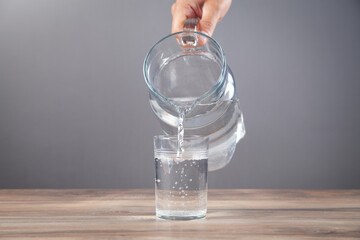 Male hand pouring water into glass. Healthy drink