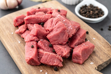 Chopped topside meat on wooden board  over stone background with seasonings