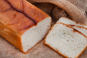 sliced fresh home baked white farm bread on rustic table with copy space