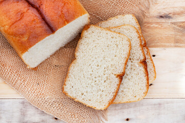sliced fresh home baked white farm bread on rustic table with copy space
