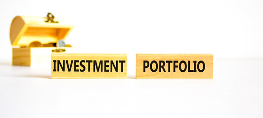Investment portfolio symbol. Wooden blocks with concept words Investment portfolio on white background. Wooden chest with coins. Business investment portfolio concept. Copy space.