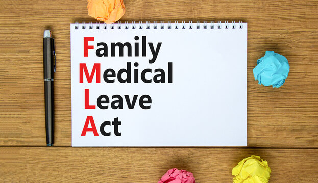 FMLA family medical leave act symbol. Concept words FMLA family medical leave act on the note on beautiful white background. Medical FMLA family medical leave act concept.