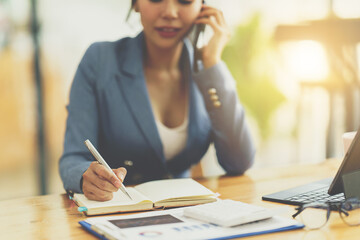 Asian businesswoman in formal suit in office happy and cheerful during using smartphone and working