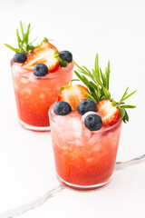 Refreshing drink with strawberry smoothie, summer sweet fruit juice with blueberries and rosemary