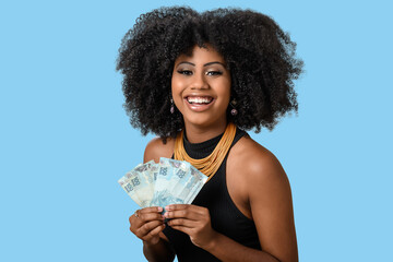 young black woman smiling holding brazilian money bills, positively surprised, space for text,...
