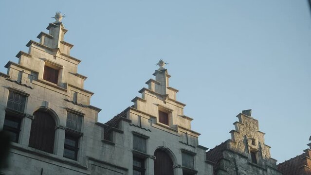 Old world building rooftops with jet streams during sunset with moving shadows time lapse 4k 60p UHD