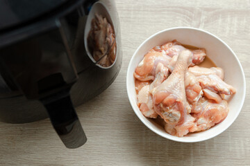 several pieces of chicken drumsticks in a white cup It's about to be fried in an oil-free fryer.