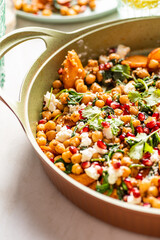 Chickpea salad with roasted yams, spinach, pomegranate, feta cheese, coriander, sesame seeds. 