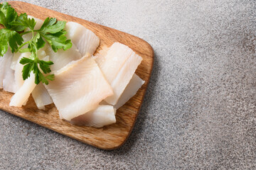 Delicacy fish smoked halibut served with parsley for eating on wooden cutting board. Close up. Rich...