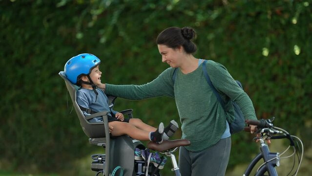 Mother and child together child sitting bicycle seat laughing with mom bonding moment