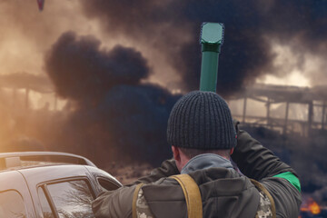 The military man looks through the periscope tube at the smoke of war