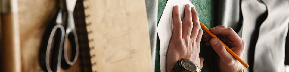 Fototapeta premium White craftsman working with leather at wooden table in workshop
