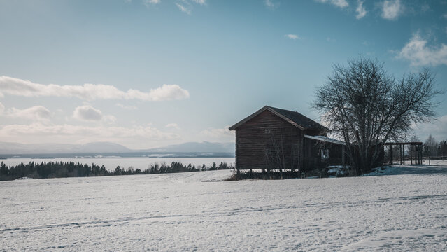 Cozy Old Abandoned Cottage (fäbod) On Lake Storsjön In Swedish Jämtland (Lapland) During Snowy Winter. Moutains  And Storsjön In The Background. 