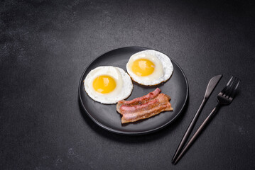 English breakfast with fried eggs, bacon, beans, tomatoes, spices and herbs