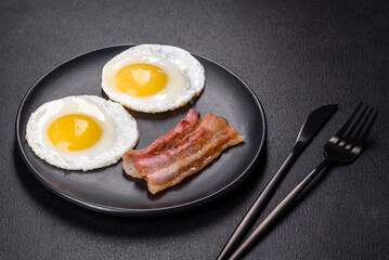 English breakfast with fried eggs, bacon, beans, tomatoes, spices and herbs