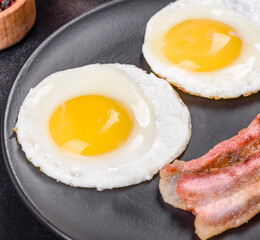 English breakfast with fried eggs, bacon, beans, tomatoes, spices and herbs