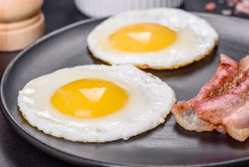 English breakfast with fried eggs, bacon, beans, tomatoes, spices and herbs