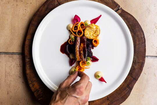 Naklejki Chef's hand detail shot of crafting fine dining appetizer at restaurant