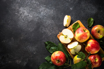 Fresh ripe apples, whole and sliced apples at black stone table. Top view with copy space.