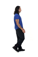 side view of a man with sportswear walking with tattoo on arms on white background