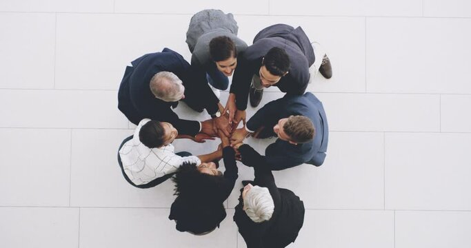 Teamwork wins every time. 4k footage of a group of businesspeople joining their hands together in a huddle.