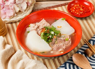 Pork Ribs and Radish Soupin a bowl with spoon and chopsticks isolated on mat side view on wooden table taiwan food