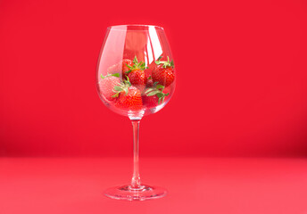 Bright juicy selected strawberries in a large glass with soda.