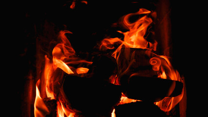 Burning firewood and coals in a stone stove. Brick oven on wood. Long tongues of flame of burning...