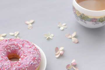 Spring dessert, Pink Donut, doughnut with colorful sprinkles, a cup of black coffee or tea, top view, mock up, copy space