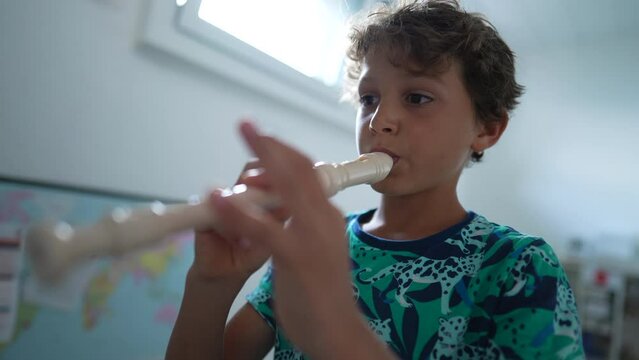 Young musician playing flute rehearsing with musical instrument