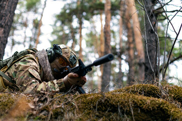 Photo of a soldier aims at the enemy during a clash. Concept of modern warfare and special forces.