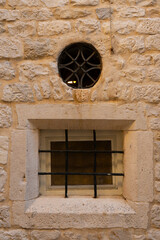 Window with bars in an old stone house. Close-up