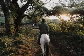 African man riding horse in forest in Tanzania