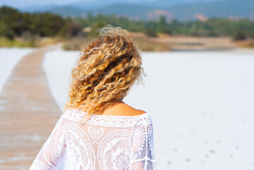Back view of blonde surf waves hairstyle woman enjoying the beach in summer holiday vacation....